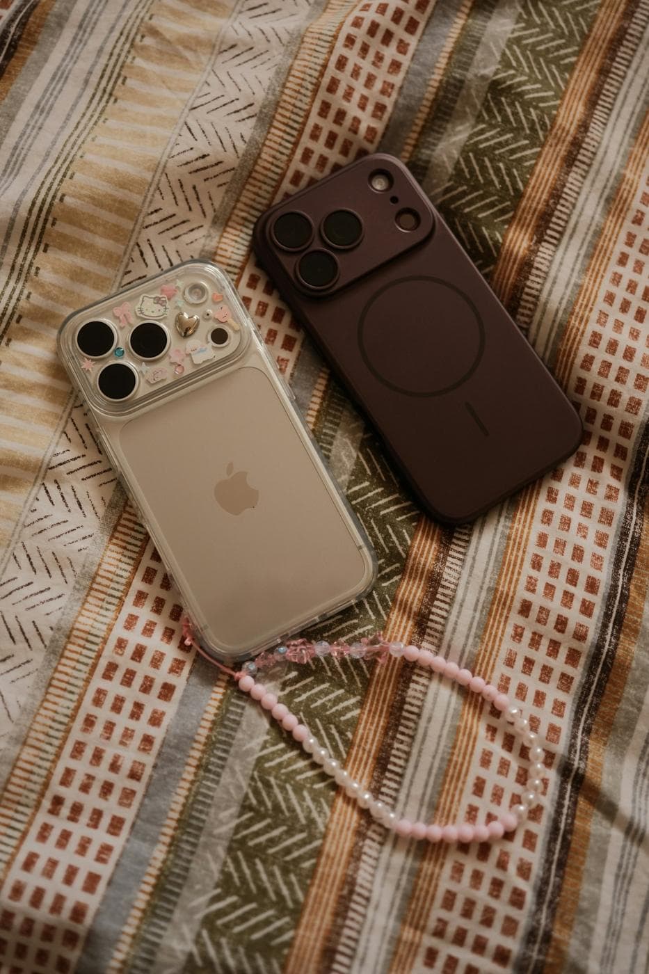 Deux téléphones dans leurs coques, posés sur un tissu avec un cordon