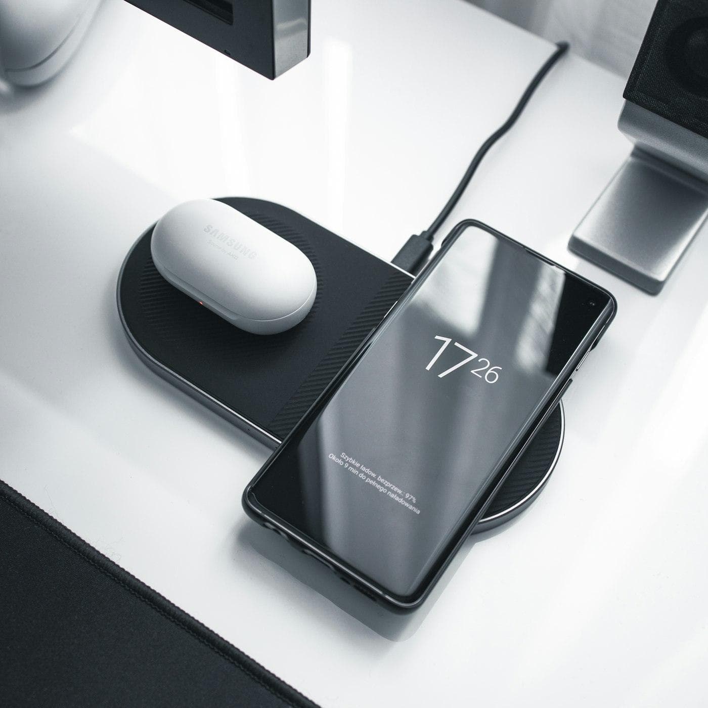 Téléphone posé sur un socle de charge, sur un bureau
