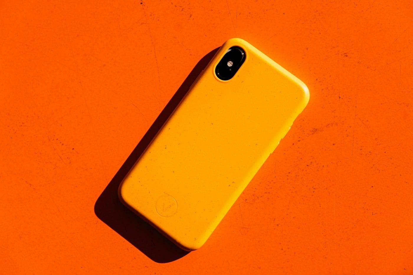 Téléphone dans une coque orange sur fond orange